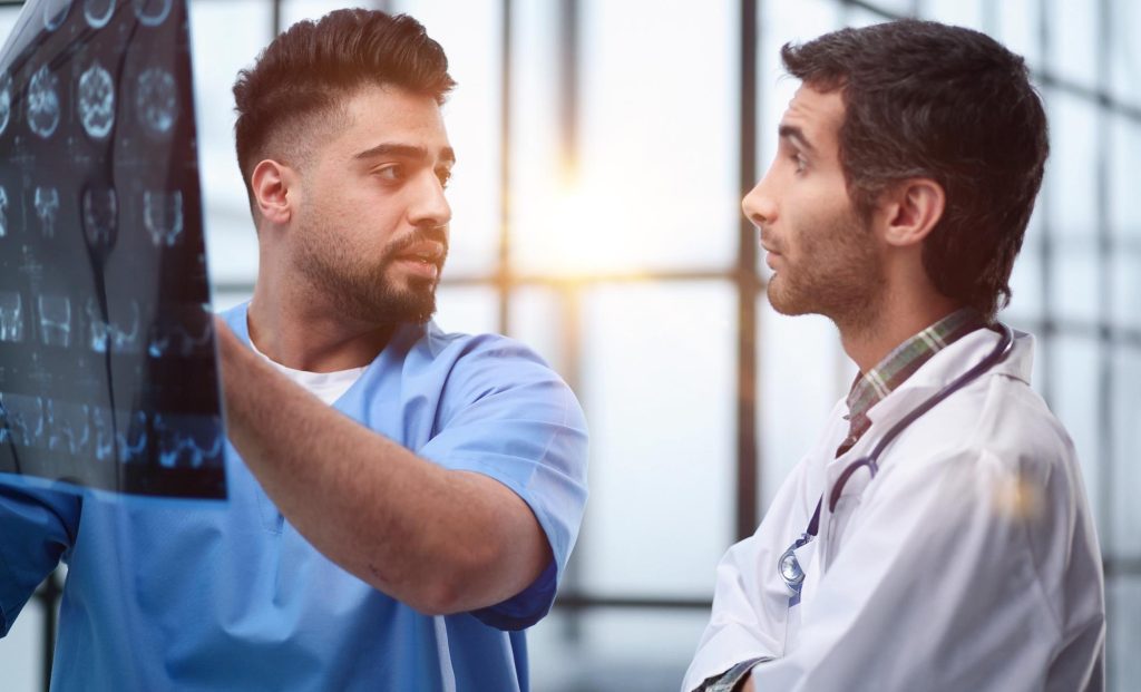 Dos médicos varones mirando una radiografía del cerebro